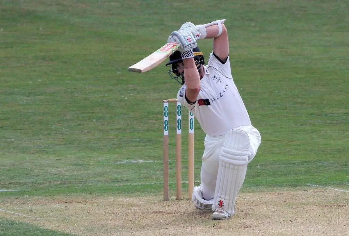 A batsman plays a square drive during a cricket match 